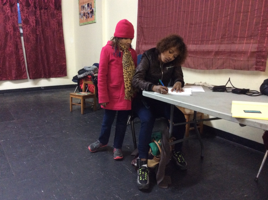 Julia fills out forms at Gregoria Flores' immigration clinic with daughter Nazary. 